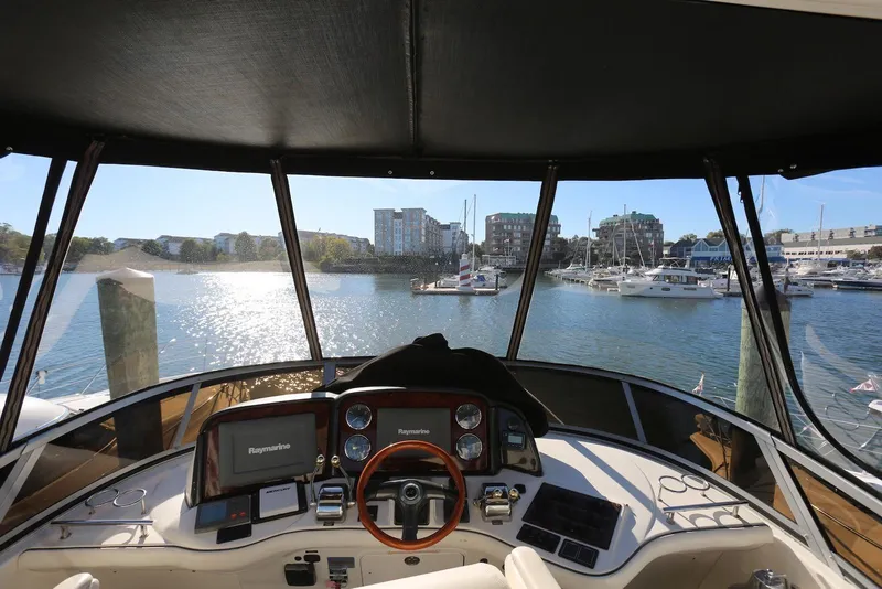 Slide: The Image of 2004 Sea Ray 420 Sedan Bridge helm view, overlooking marina with boats and buildings. - 61