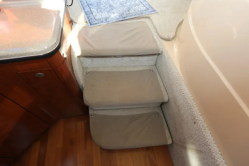 Slide: The Image of Interior stairs of 2004 Sea Ray 420 Sedan Bridge with carpeted steps and wooden flooring. - 73