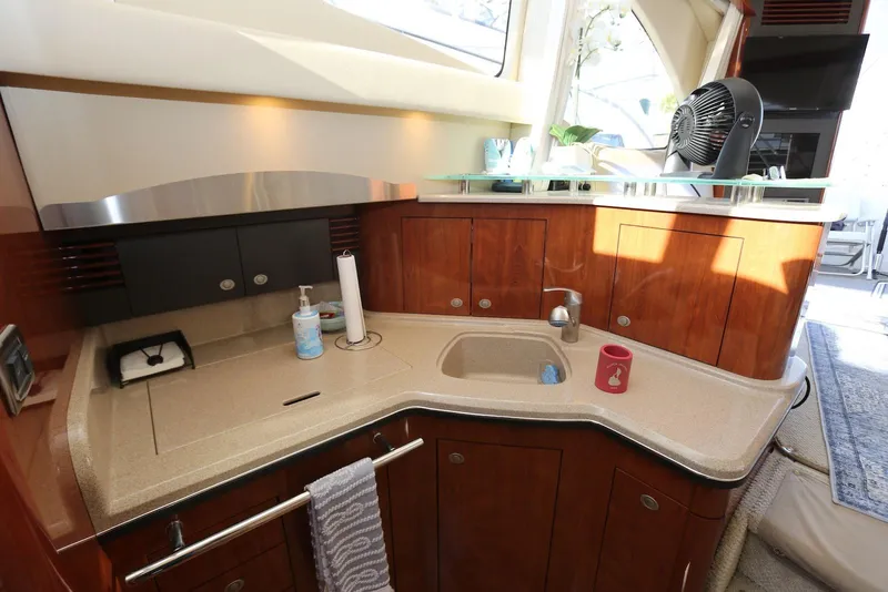 Slide: The Image of Luxurious 2004 Sea Ray 420 Sedan Bridge yacht kitchen with modern amenities and elegant wood cabinetry. - 74