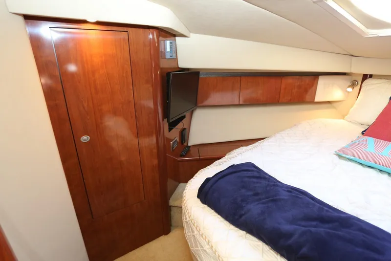 Slide: The Image of Luxurious cabin interior of 2004 Sea Ray 420 Sedan Bridge with wood accents and cozy bedding. - 81