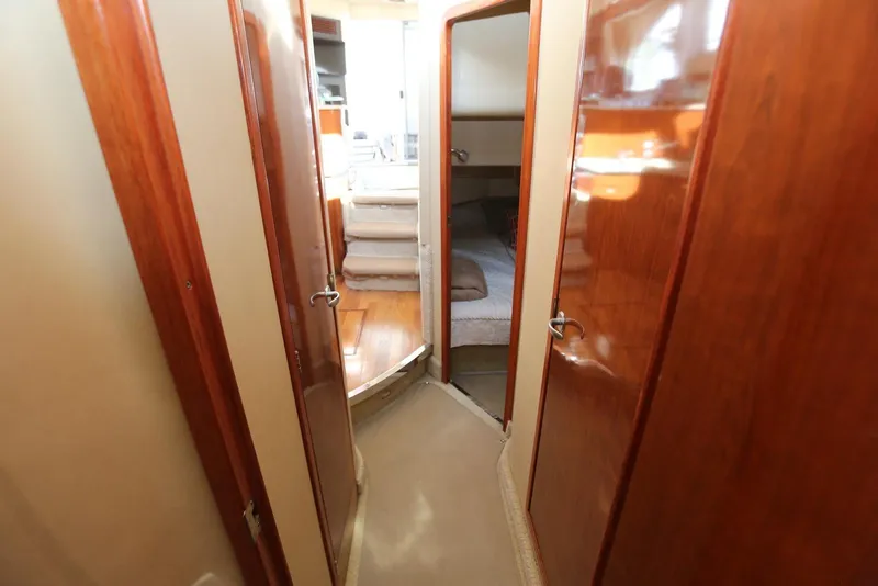 Slide: The Image of Interior hallway of 2004 Sea Ray 420 Sedan Bridge yacht with wooden doors and carpeted floor. - 85