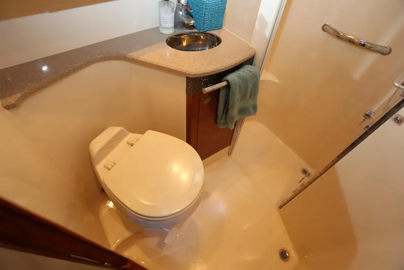 Slide: The Image of 2004 Sea Ray 420 Sedan Bridge bathroom with toilet, sink, and shower area. - 88