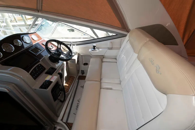 Slide: The Image of 2009 Sea Ray 310 Sundancer cockpit with steering wheel and plush seating. - 4