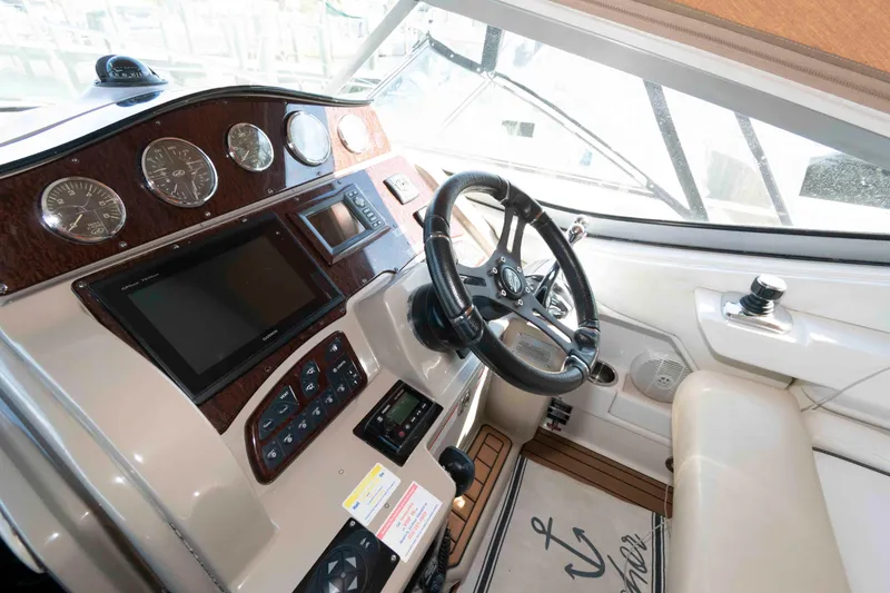 Slide: The Image of 2009 Sea Ray 310 Sundancer helm with steering wheel, gauges, and navigation controls. - 5
