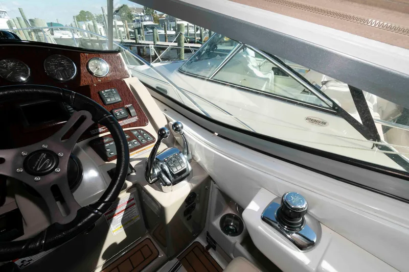 Slide: The Image of 2009 Sea Ray 310 Sundancer helm with steering wheel and control panel, docked at marina. - 6