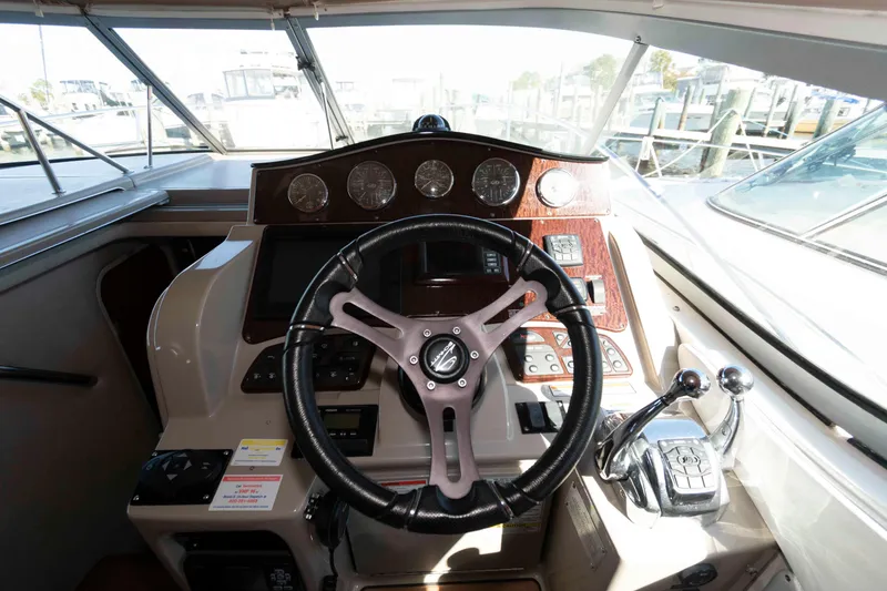 Slide: The Image of 2009 Sea Ray 310 Sundancer helm with steering wheel and control panel. - 7