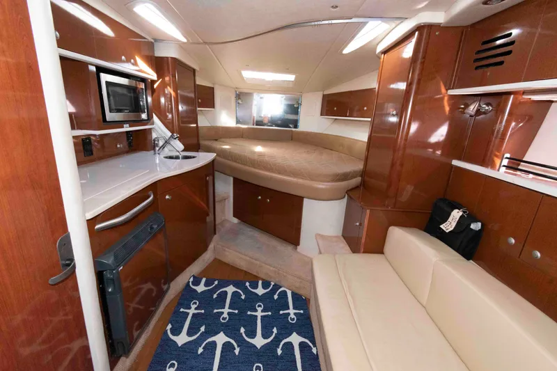 Slide: The Image of 2009 Sea Ray 310 Sundancer interior with kitchenette, bed, and seating area. - 8