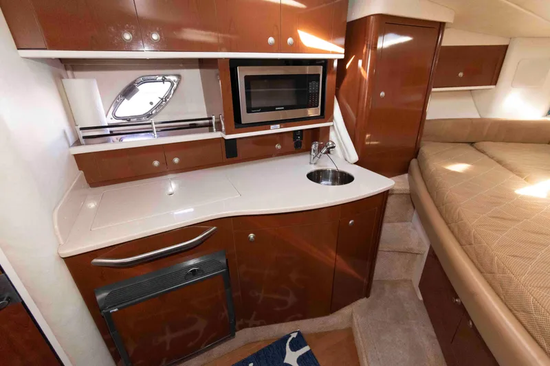 Slide: The Image of 2009 Sea Ray 310 Sundancer interior with kitchenette, microwave, sink, and bed. - 9