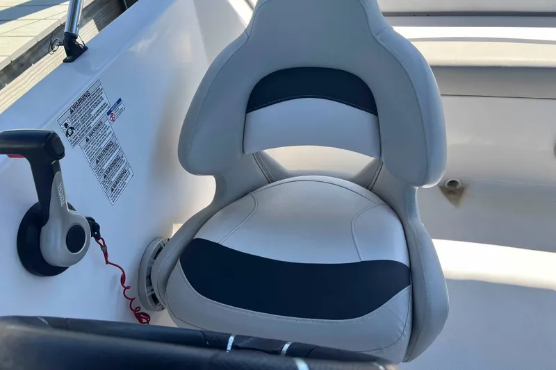 Slide: The Image of 2018 Starcraft SVX 190 OB boat seat with control lever, white and black design. - 22