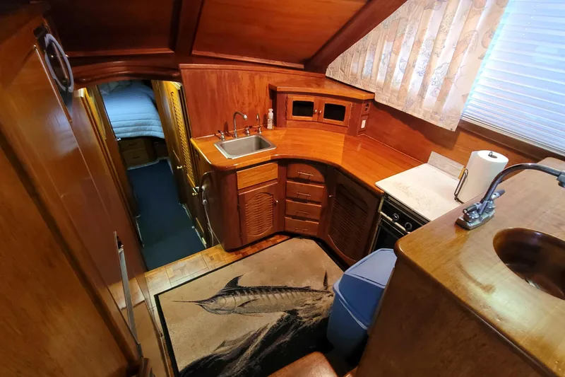 Slide: The Image of 1984 Tiffany 50 Convertible yacht interior with wooden cabinetry and compact kitchen area. - 13