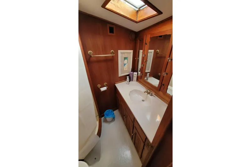 Slide: The Image of 1984 Tiffany 50 Convertible yacht bathroom with wood paneling and skylight. - 19