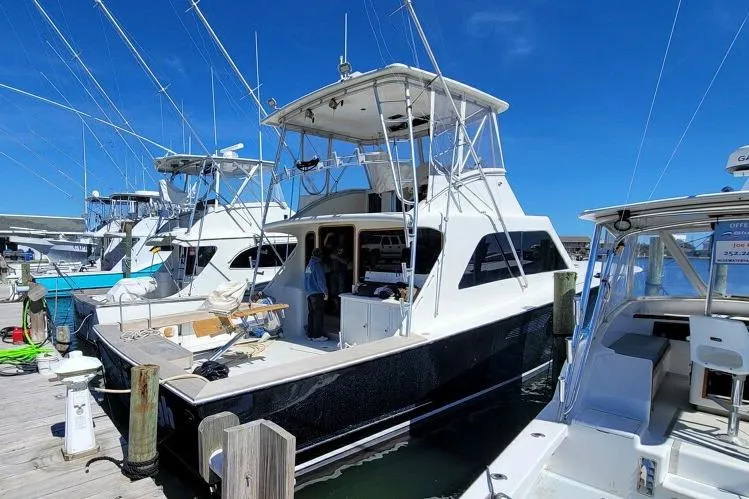 Slide: The Image of 1984 Tiffany 50 Convertible yacht docked at marina under clear blue sky. - 5