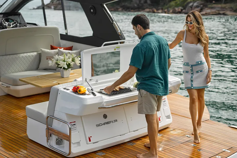 Slide: The Image of Couple enjoying a barbecue on a 2026 Schaefer 375 yacht, with scenic water backdrop. - 31