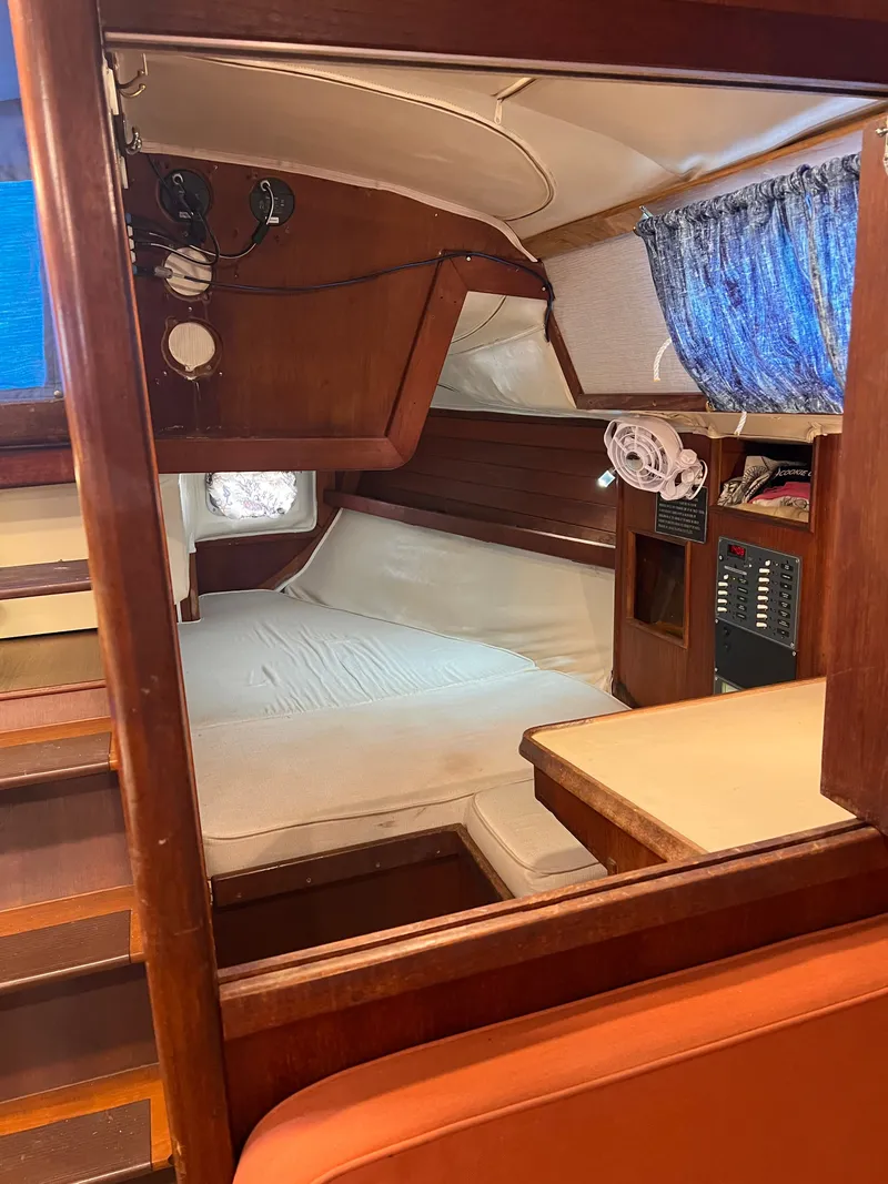 Slide: The Image of Cozy interior of 1981 Ericson 38 sailboat with wooden furnishings and a comfortable sleeping area. - 12