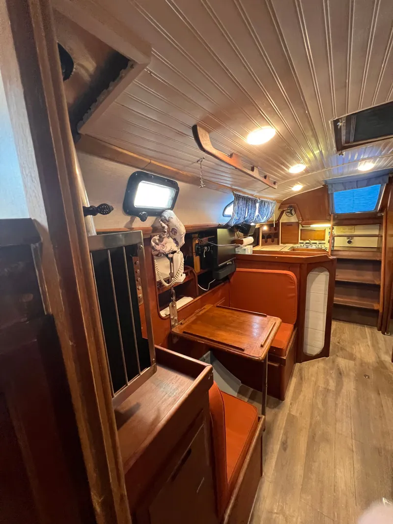 Slide: The Image of Interior of 1981 Ericson 38 sailboat with wooden furnishings and cozy seating area. - 14