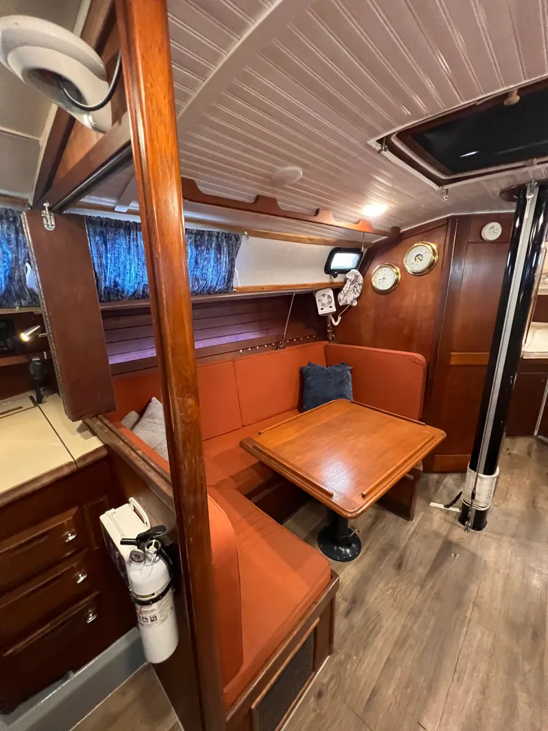 Slide: The Image of Cozy interior of 1981 Ericson 38 sailboat with wooden table and seating area. - 17