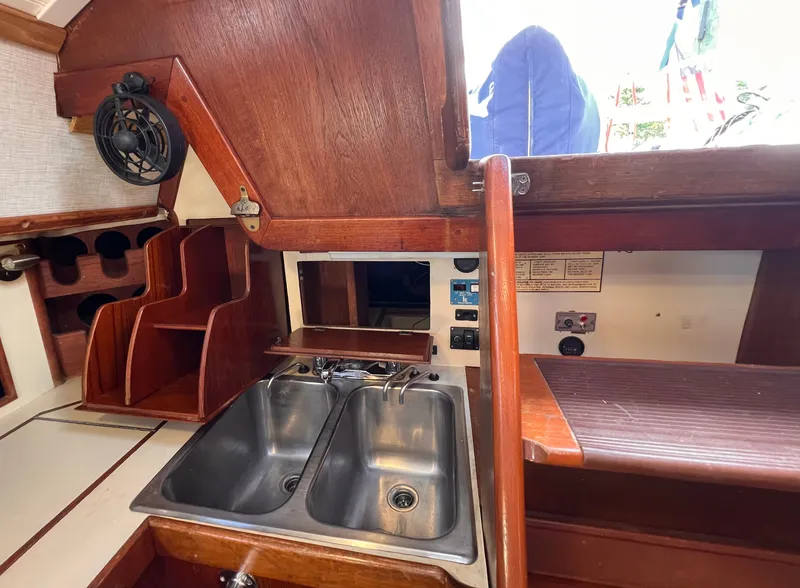 Slide: The Image of Interior of 1981 Ericson 38 sailboat galley with dual sinks and wooden cabinetry. - 22