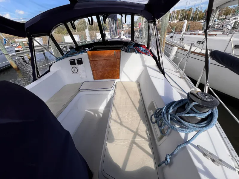 Slide: The Image of Cockpit of 1981 Ericson 38 sailboat with seating, winch, and ropes in a marina setting. - 3