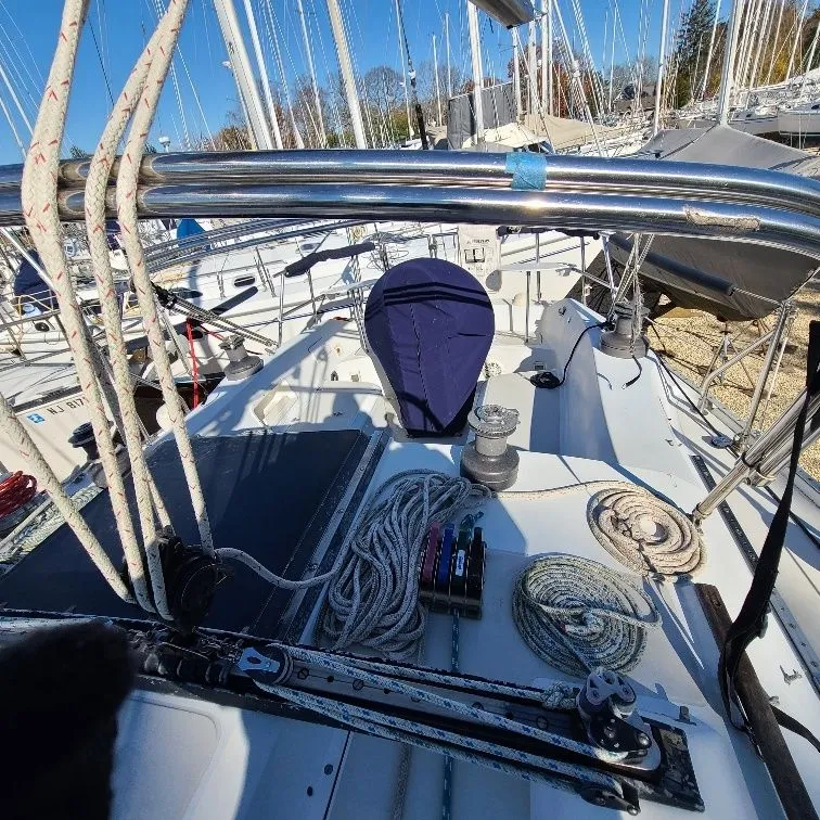 Slide: The Image of 1981 Ericson 38 sailboat deck with ropes, winches, and rigging under clear blue sky. - 6