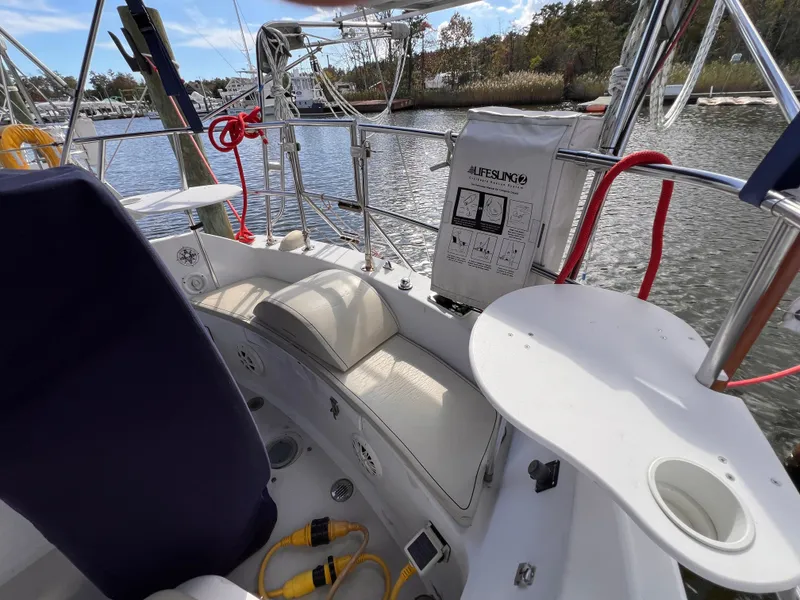 Slide: The Image of Cockpit of 1981 Ericson 38 sailboat with lifesling and seating, docked by the water. - 8
