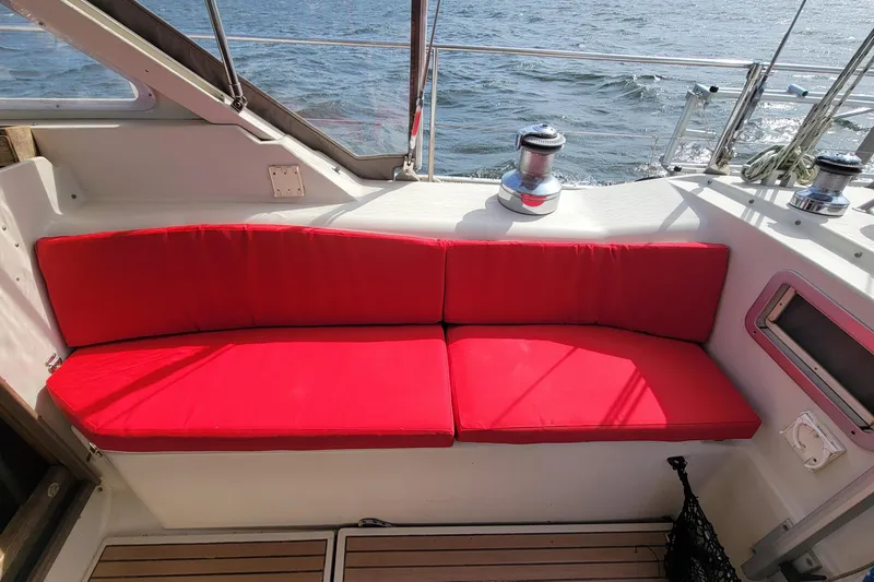 Slide: The Image of Red cushioned seating on 1993 Amel Santorin sailboat deck with ocean view. - 13