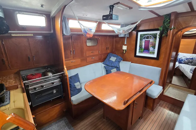 Slide: The Image of Cozy interior of a 1993 Amel Santorin sailboat with wooden cabinetry and dining area. - 16