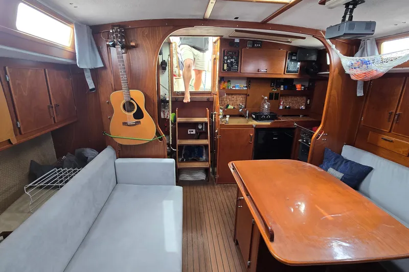 Slide: The Image of Interior of 1993 Amel Santorin sailboat with wooden furnishings and guitar on wall. - 17