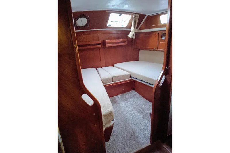 Slide: The Image of Cozy cabin interior of 1993 Amel Santorin sailboat with wooden finish and cushioned seating. - 19