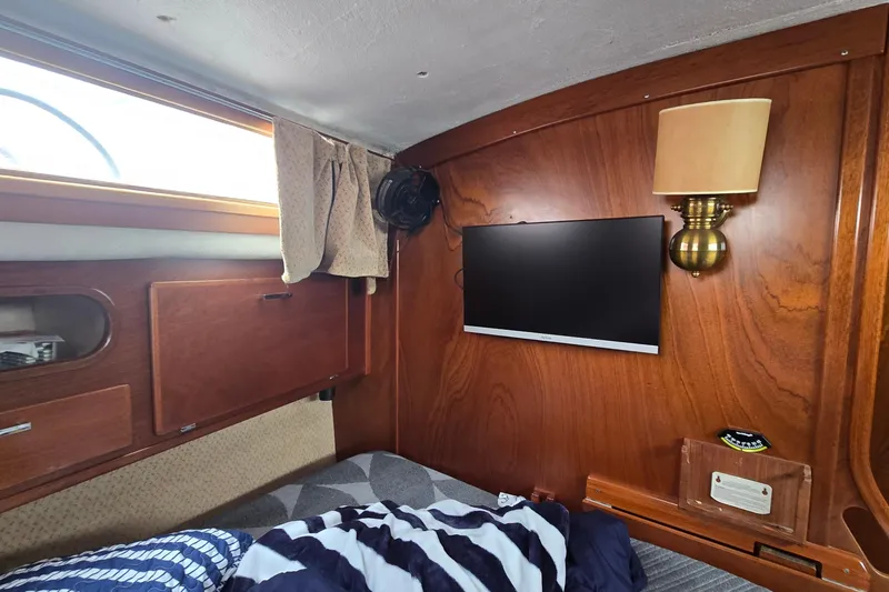 Slide: The Image of Interior of 1993 Amel Santorin yacht cabin with TV, lamp, and wooden paneling. - 21