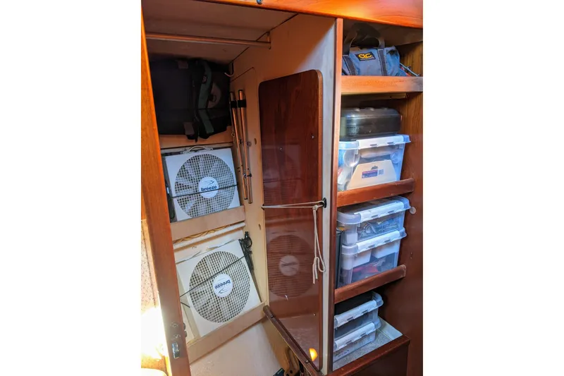 Slide: The Image of Storage area in a 1993 Amel Santorin yacht with fans and organized containers. - 27