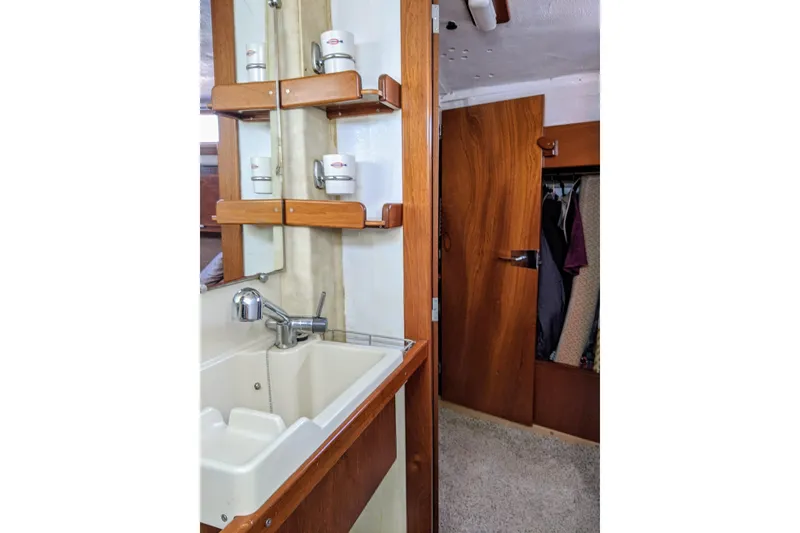 Slide: The Image of Interior of 1993 Amel Santorin yacht showing sink, wooden shelves, and closet. - 30