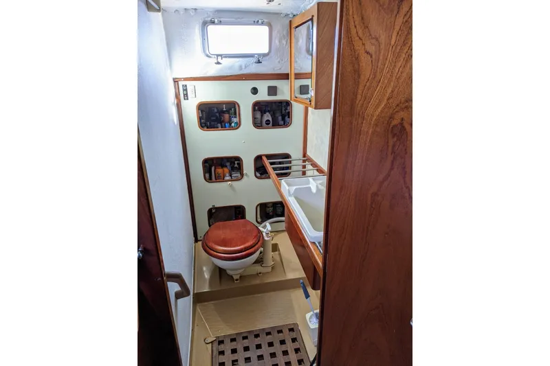 Slide: The Image of 1993 Amel Santorin yacht bathroom with wooden accents and storage shelves. - 33