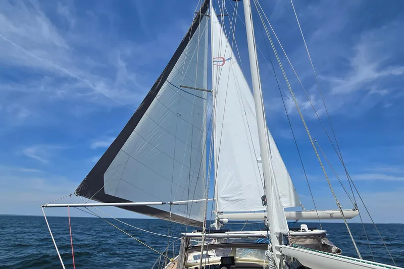 Slide: The Image of Sailing yacht Amel Santorin 1993 with sails unfurled on open sea under blue sky. - 7