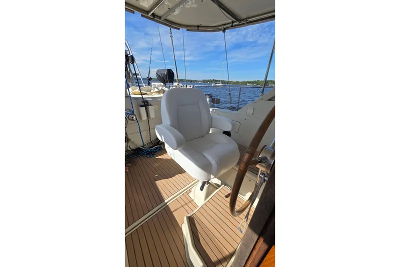 Slide: The Image of Captain's chair on 1993 Amel Santorin yacht, overlooking serene waters and clear blue sky. - 8