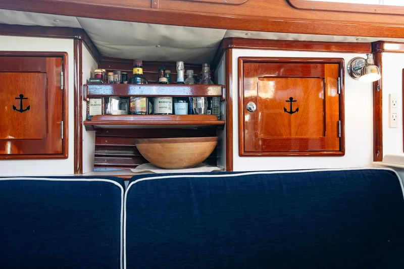Slide: The Image of Interior of 2007 Morris Yachts M42 with wooden cabinets and a stocked bar shelf. - 26