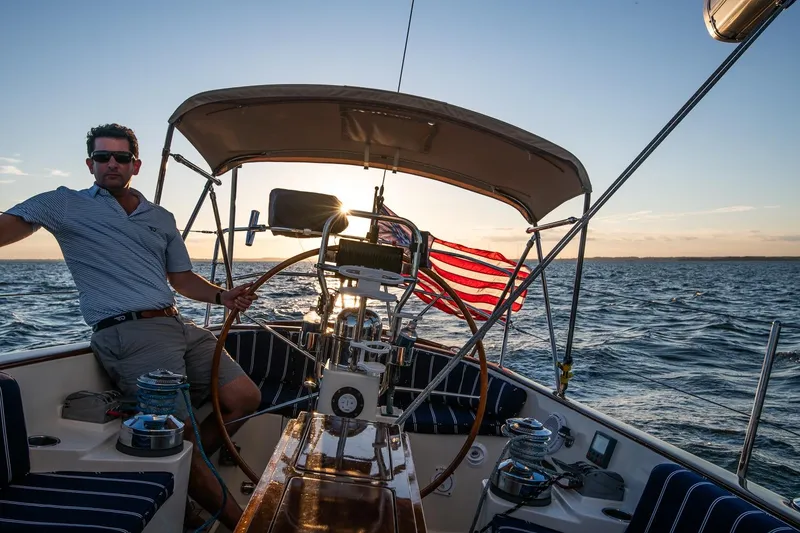 Slide: The Image of Man sailing a 2007 Morris Yachts M42 at sunset, American flag waving. - 6