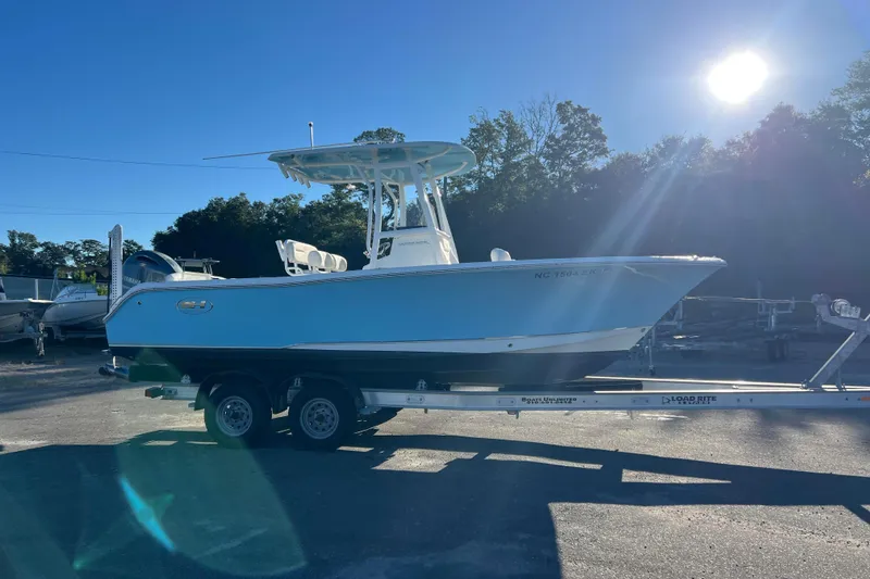 The Image of 2019 Sea Hunt Ultra 225 boat on trailer under bright sunlight. - 1