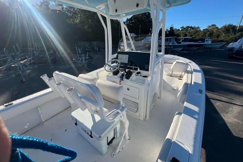 Slide: The Image of 2019 Sea Hunt Ultra 225 boat interior with steering console and seating, in outdoor setting. - 10