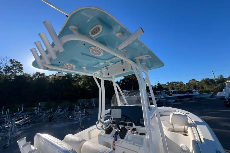 Slide: The Image of 2019 Sea Hunt Ultra 225 boat with T-top and console, parked outdoors. - 11