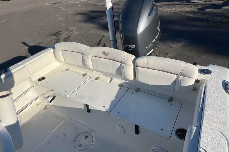 Slide: The Image of 2019 Sea Hunt Ultra 225 boat interior with Yamaha 150 engine, featuring white seating and storage. - 7