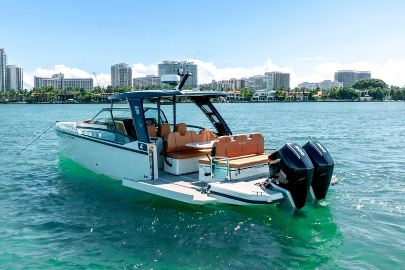 Slide: The Image of 2021 Saxdor 320 GTO boat on water with city skyline in background. - 11