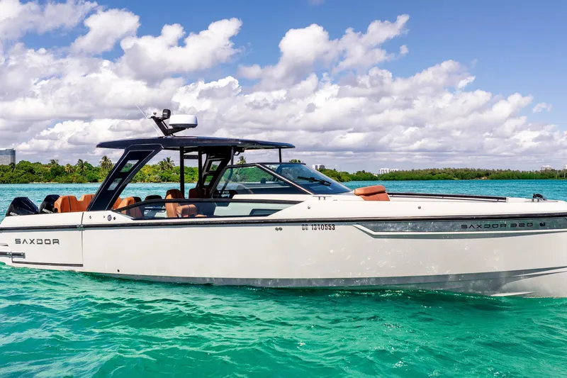 Slide: The Image of 2021 Saxdor 320 GTO boat on turquoise water under a partly cloudy sky. - 14