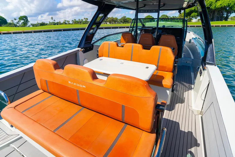 Slide: The Image of 2021 Saxdor 320 GTO boat with orange seating, sleek design, and scenic water backdrop. - 18