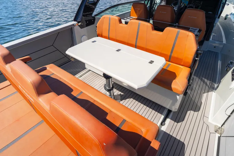 Slide: The Image of Luxurious 2021 Saxdor 320 GTO boat interior with orange seating and a white table. - 19