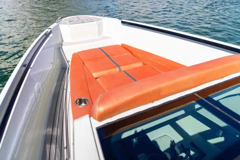 Slide: The Image of 2021 Saxdor 320 GTO boat with orange seating, docked on calm water. - 33