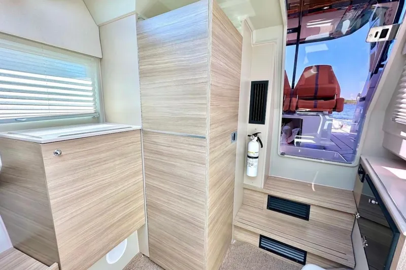 Slide: The Image of Interior of 2021 Saxdor 320 GTO boat with modern wood finish and fire extinguisher. - 47