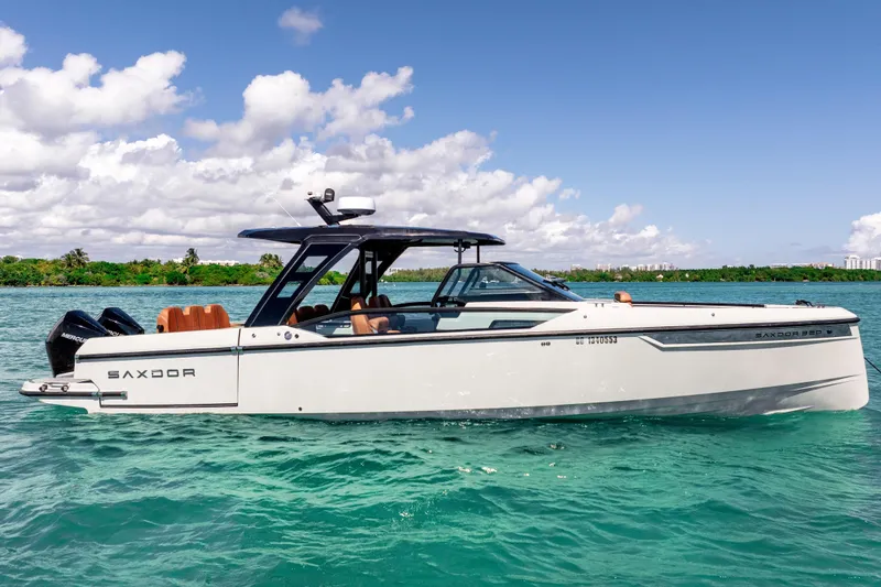 Slide: The Image of 2021 Saxdor 320 GTO boat cruising on clear blue water under a sunny sky. - 7