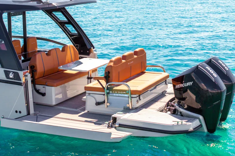 Slide: The Image of 2021 Saxdor 320 GTO boat with seating and twin Mercury engines on clear blue water. - 8