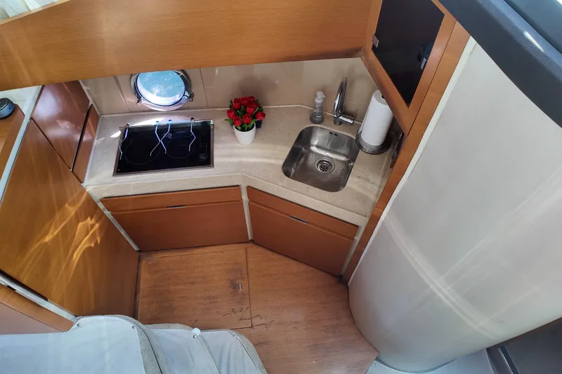 Slide: The Image of Compact kitchen area in 2012 Azimut 40 FLY yacht with sink, stove, and porthole. - 32