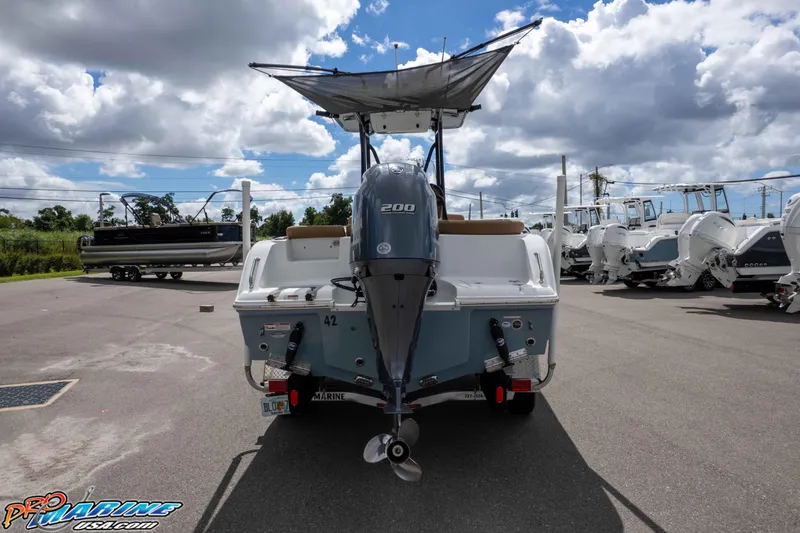 Slide: The Image of 2022 Sea Hunt Ultra 229 boat with outboard motor in a marina under cloudy sky. - 10